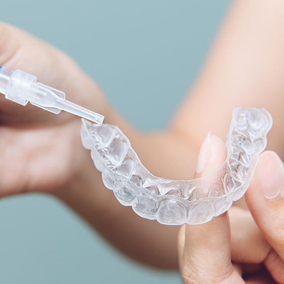 Close up of hands holding tray for teeth whitening