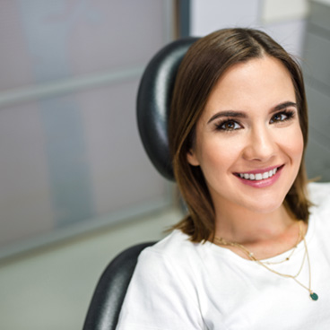 Female dental patient smiling in treatment chair