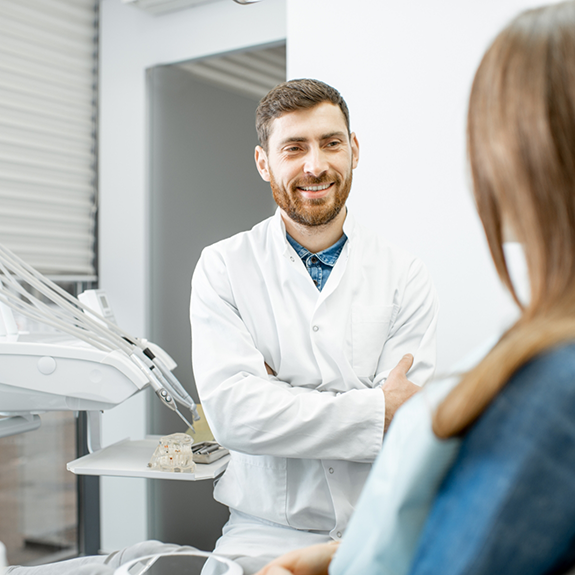 Bearded dentist talking to a patient