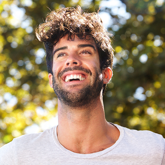 Close up of bearded man smiling outside