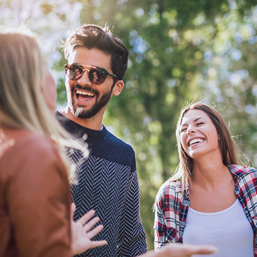 Man and woman laughing outside on sunny day