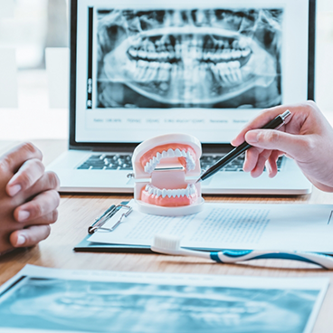 Model of teeth on desk with X ray in background