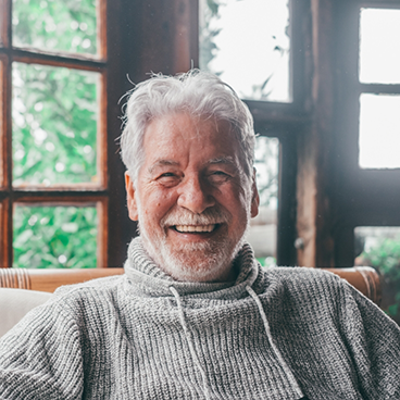 Man in grey sweater sitting in a cabin