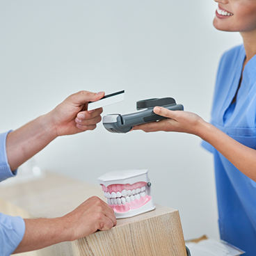 Patient using credit card with team member holding card reader