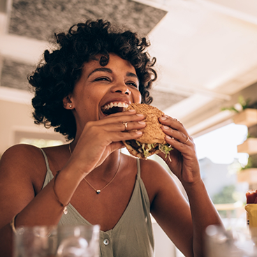 Smiling woman about to eat a burger