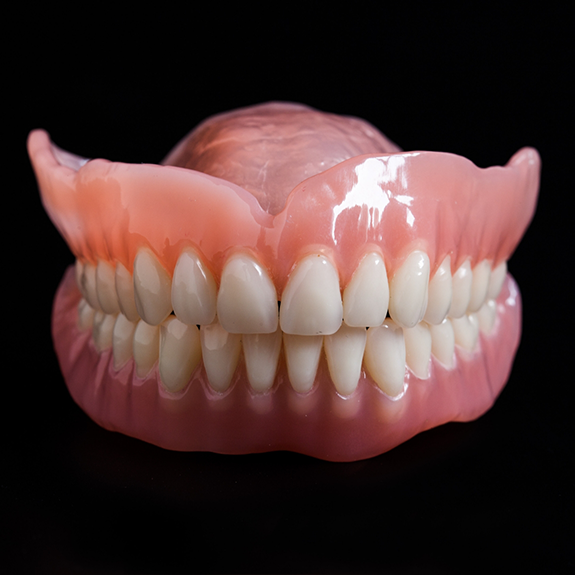 Close up of full dentures on black surface