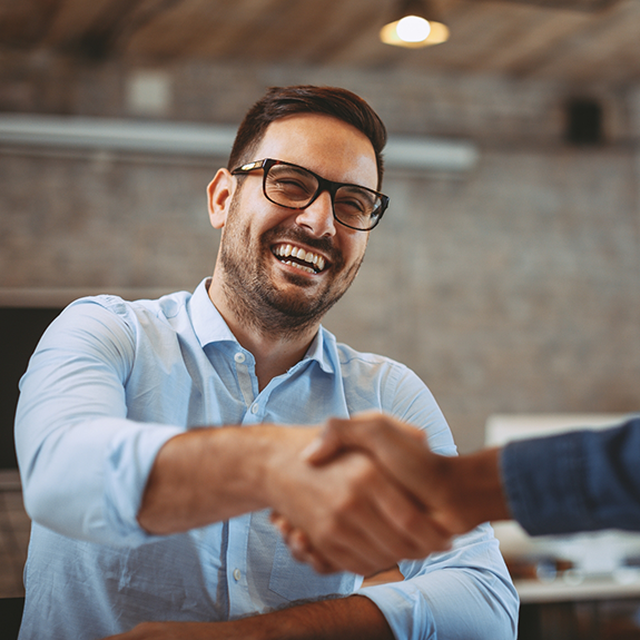 Man with glasses shaking dentists hand