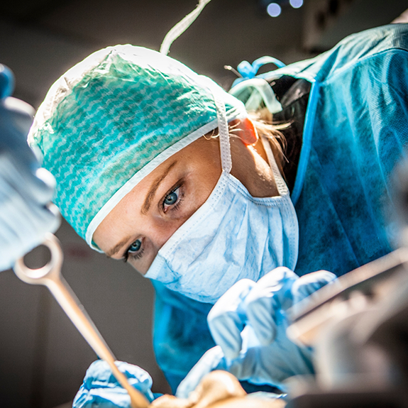 Female dentist with mask treating a patient