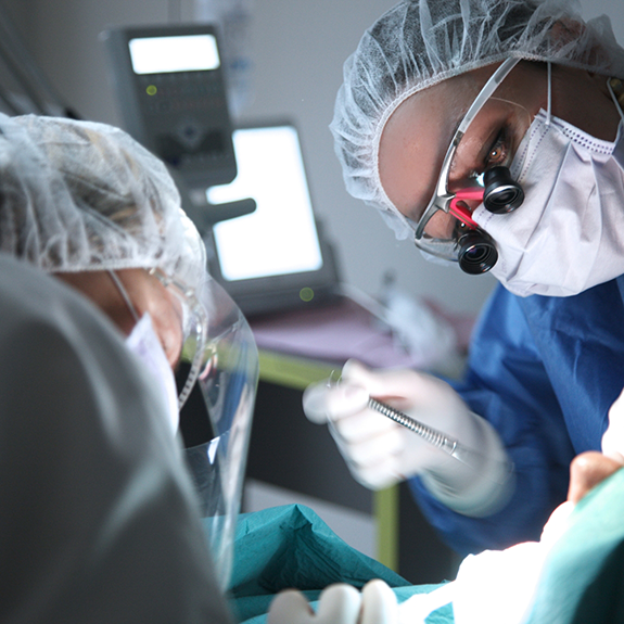 Close up of oral surgeon performing dental implant surgery