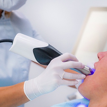 Dental team member capturing digital impression of patient’s teeth