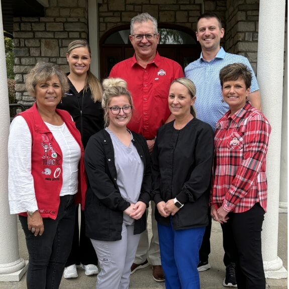 Dental team standing outside of building and smiling