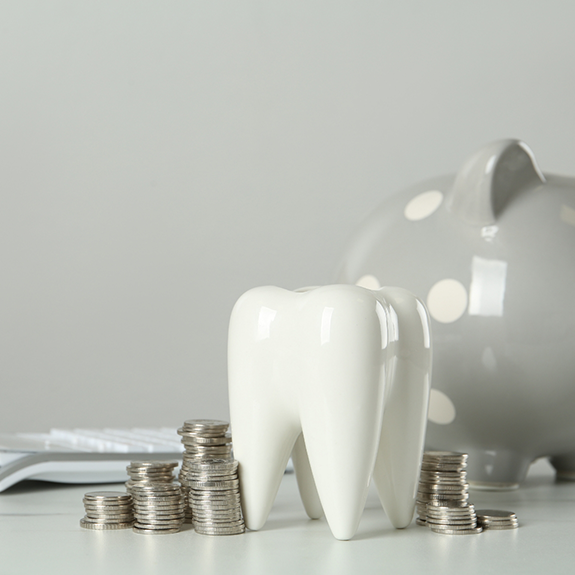 Model of tooth next to stacks of coins