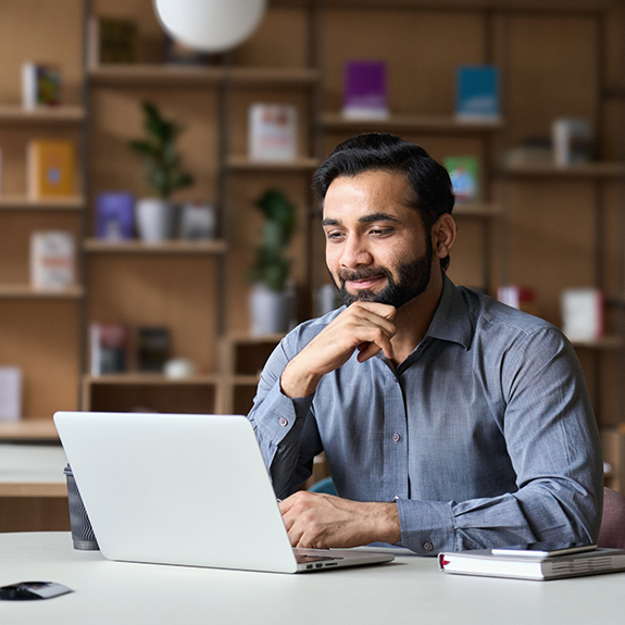 Bearded man working on a laptop