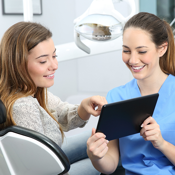 Patient pointing to tablet held by dentist