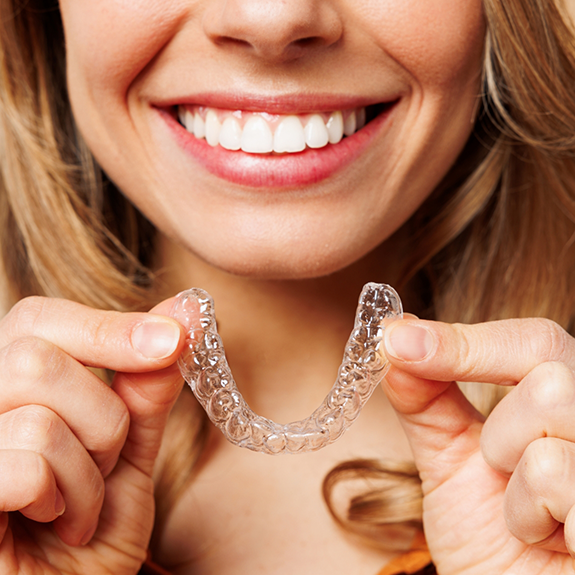 Close up of woman holding a clear aligner