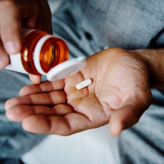 Close up of hand holding a pill