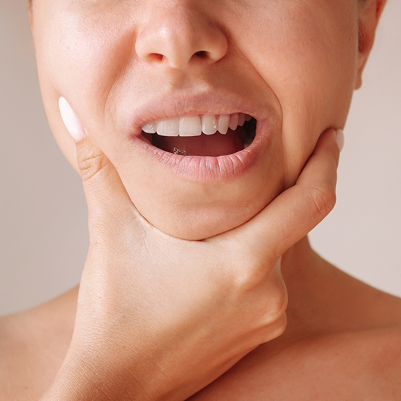 Woman rubbing her jaw in pain