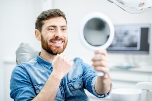 Patient admiring his smile after full mouth reconstruction